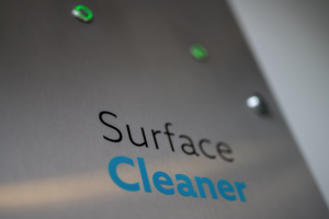 Vorderansicht des SurfaceCleaner-100 Edelstahlgehäuses mit grün leuchtenden Druckknöpfen